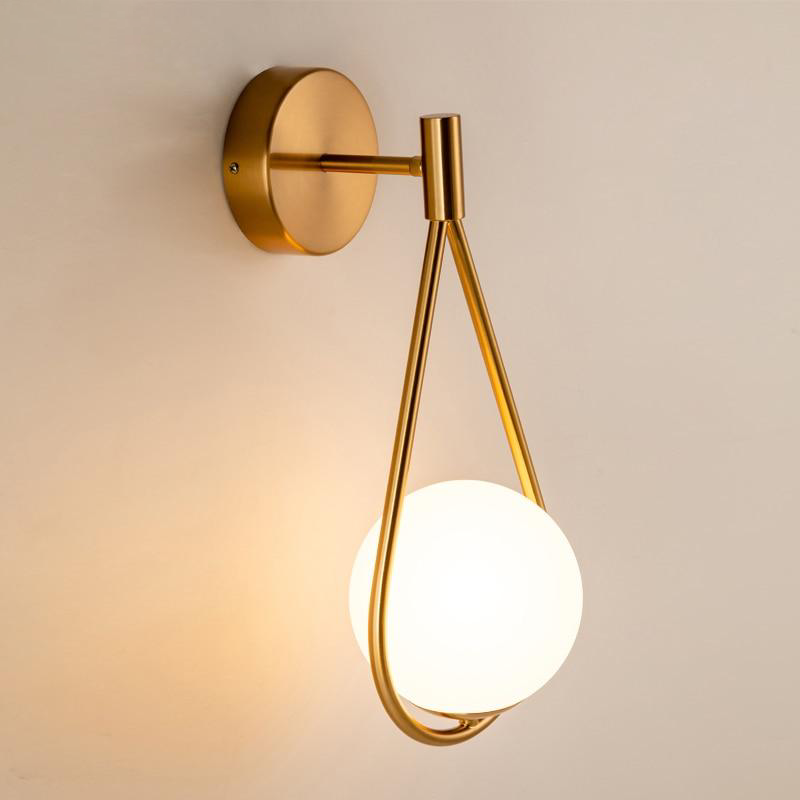 Loop Brass and Sphere Sconce with frosted glass globe brass finish loop detail and round metal backplate