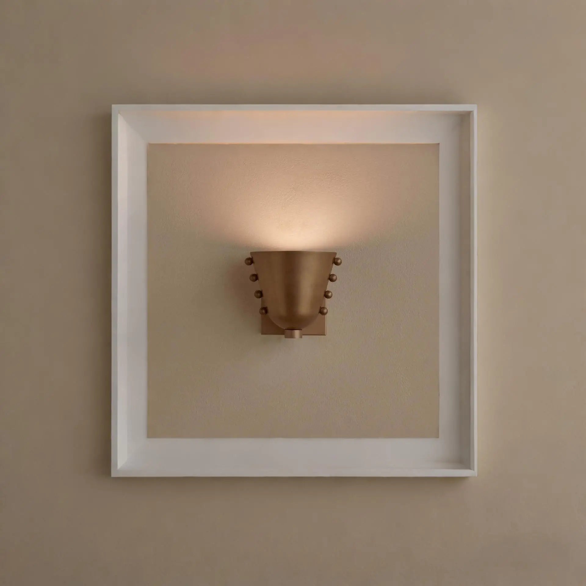 Metal wall sconce with wine glass silhouette casting soft ambient uplight in modern interior setting