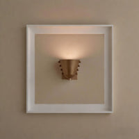 Metal wall sconce with wine glass silhouette casting soft ambient uplight in modern interior setting