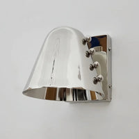 Metal wall sconce with wine glass silhouette casting soft ambient uplight in modern interior setting