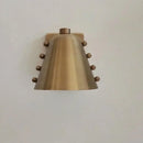 Metal wall sconce with wine glass silhouette casting soft ambient uplight in modern interior setting