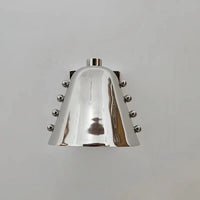 Metal wall sconce with wine glass silhouette casting soft ambient uplight in modern interior setting