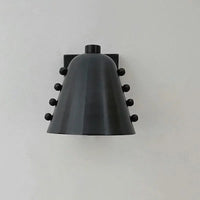 Metal wall sconce with wine glass silhouette casting soft ambient uplight in modern interior setting
