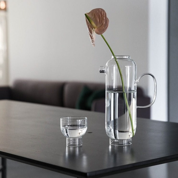 tall round clear glass pitcher and cup
