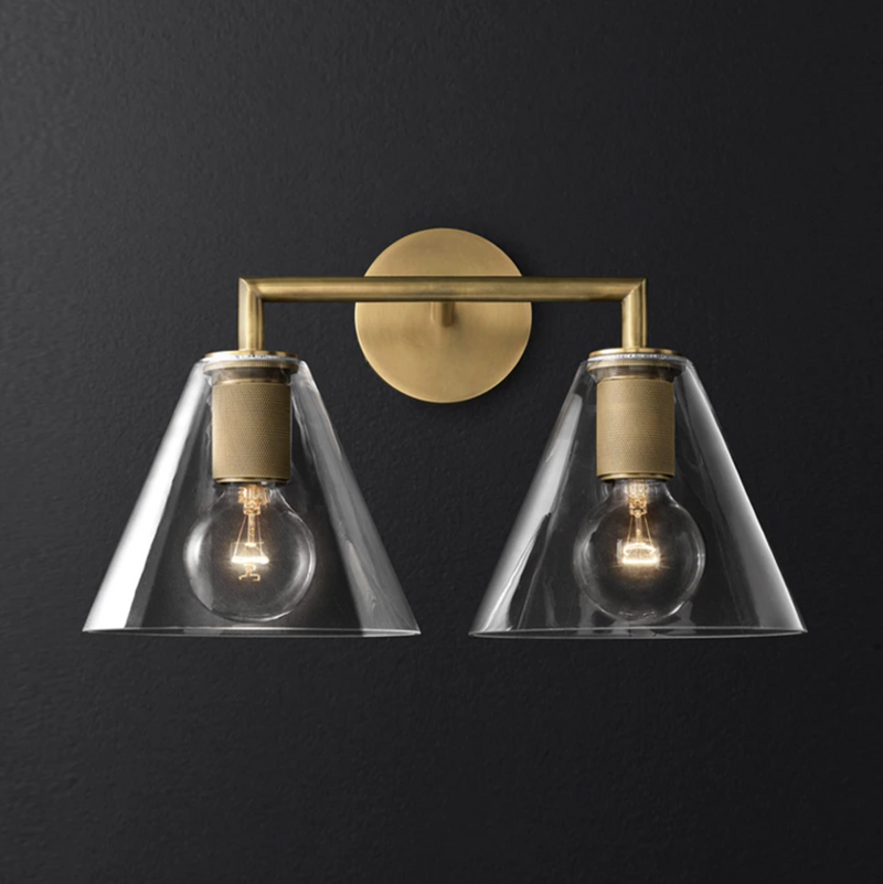 Wall-mounted double sconce with brushed brass finish and glass shades