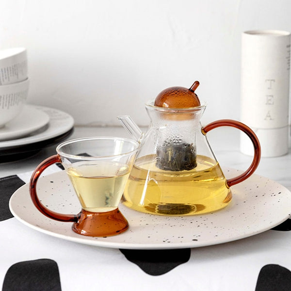triangular clear borosilicate glass tea pot and cup with amber thin handle
