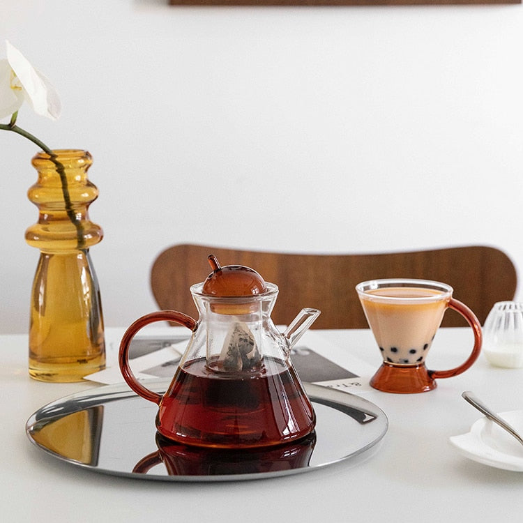 triangular clear borosilicate glass tea pot and cup with amber thin handle