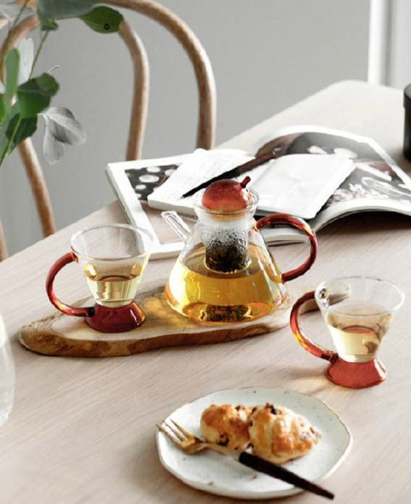 triangular clear borosilicate glass tea pot and cup with amber thin handle
