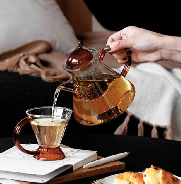 triangular clear borosilicate glass tea pot and cup with amber thin handle