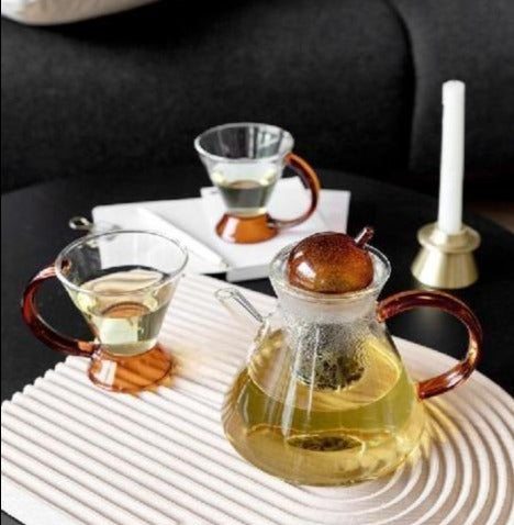triangular clear borosilicate glass tea pot and cup with amber thin handle