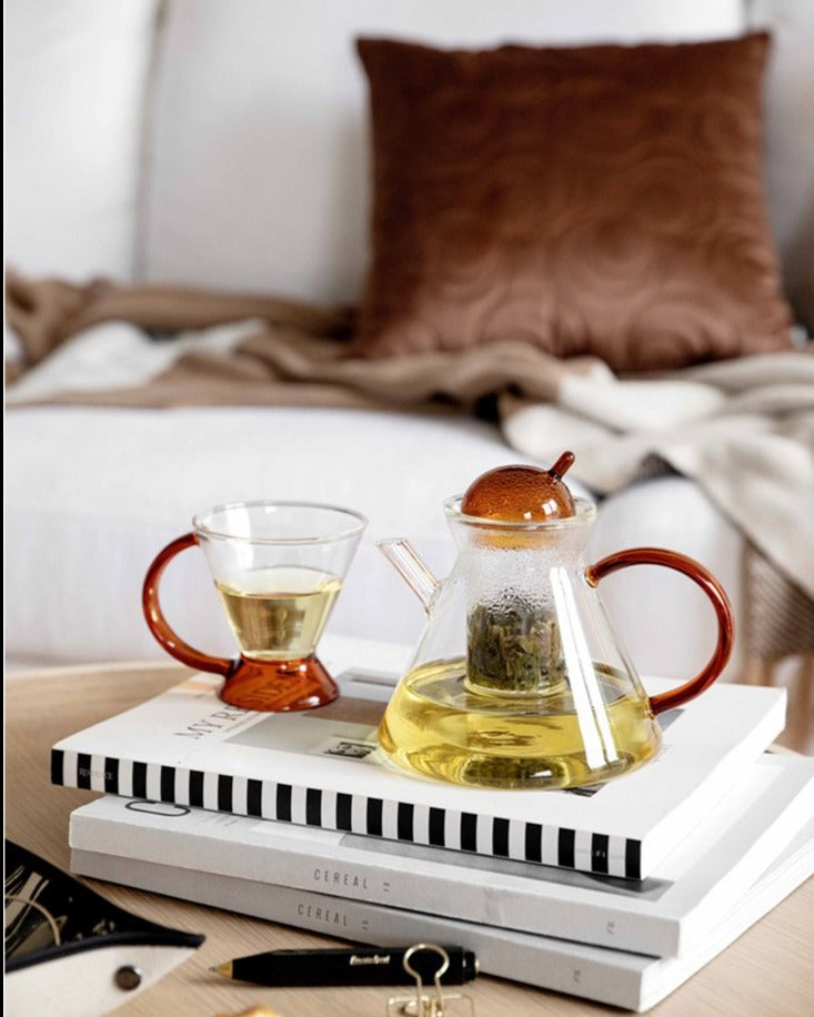 triangular clear borosilicate glass tea pot and cup with amber thin handle