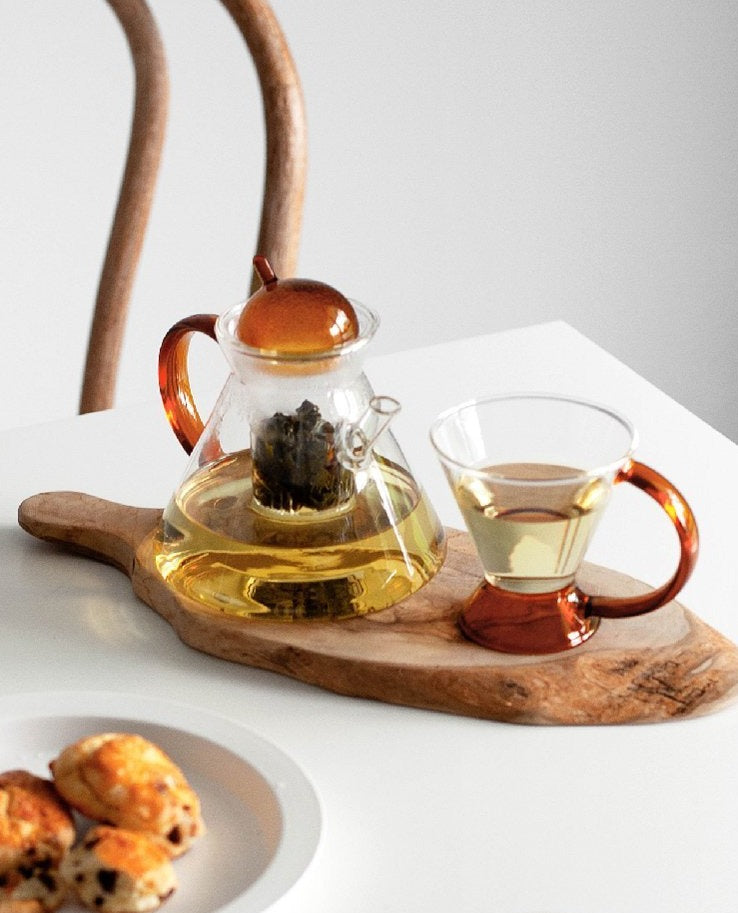 triangular clear borosilicate glass tea pot and cup with amber thin handle
