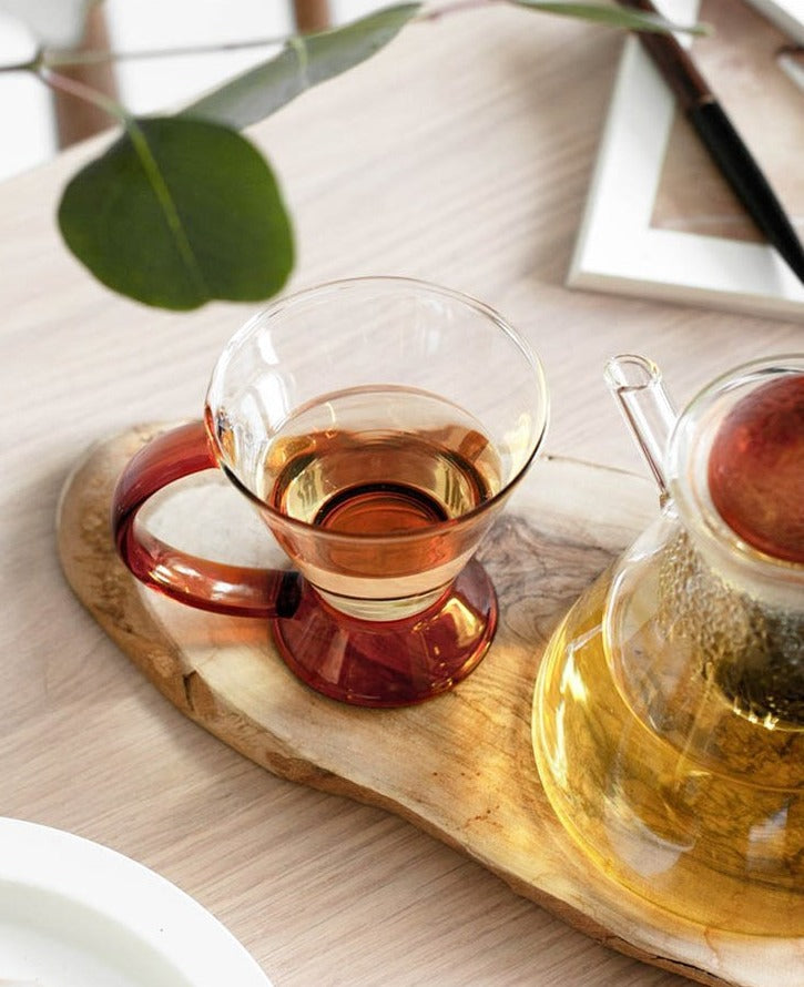 triangular clear borosilicate glass tea pot and cup with amber thin handle