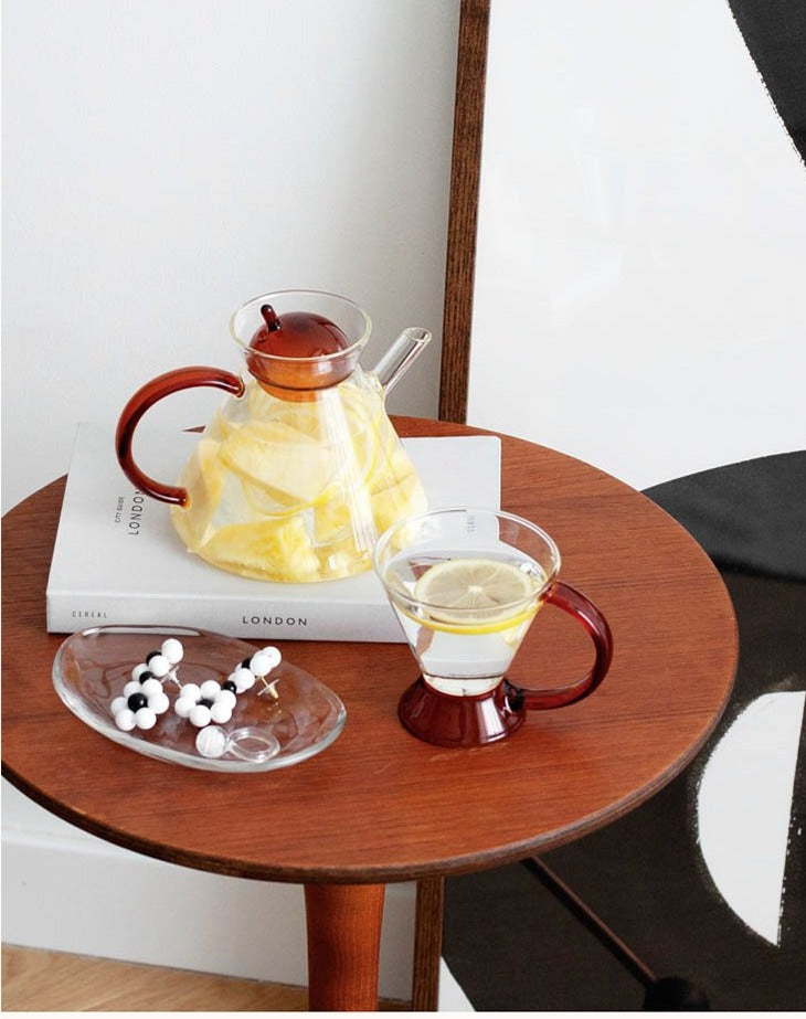 triangular clear borosilicate glass tea pot and cup with amber thin handle