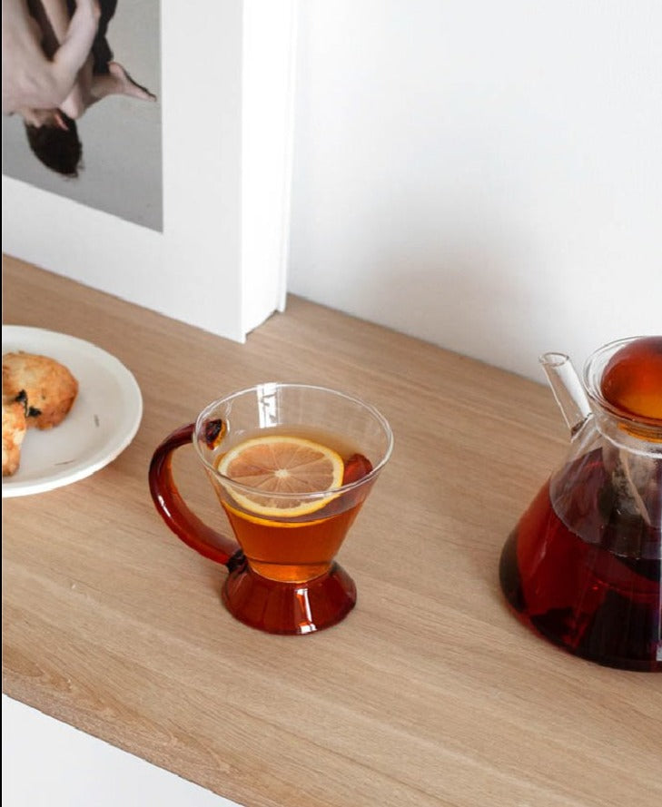 triangular clear borosilicate glass tea pot and cup with amber thin handle
