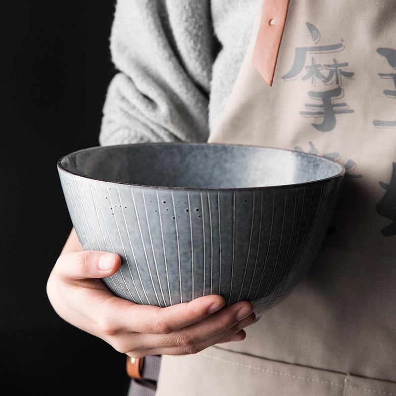 Grey silver blue stripe pattern porcelain ceramic bowl hold by hand